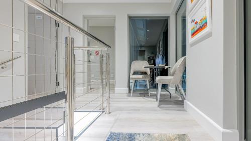 a hallway with glass doors and a table with chairs at Cliff Haven in Struisbaai