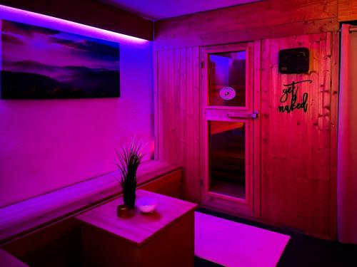 a room with purple lights and a table and a window at NOVA Romantic Luxus Relax Apartments mit Sauna, Nürburgring, Adenauer Forst in Adenau