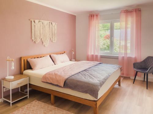 Un dormitorio con una cama con paredes rosas y una ventana en NOVA Romantic Luxus Relax Apartments mit Sauna, Nürburgring, Adenauer Forst en Adenau