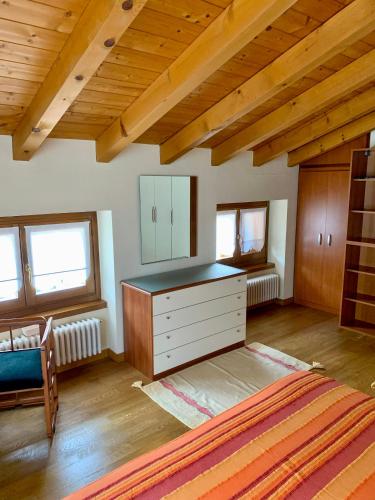 sypialnia z komodą w pokoju z drewnianym sufitem w obiekcie Comfortable Villa with private garden - Colico Center w mieście Colico