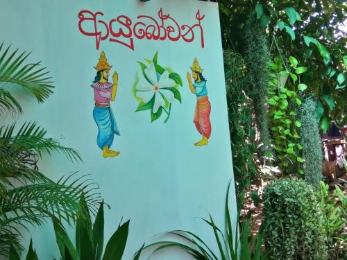 un segno per un giardino con tre donne sopra di Night Jusmine Holiday Home a Anuradhapura
