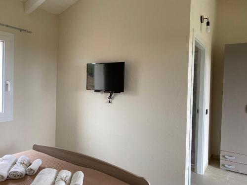 a bedroom with a bed with a tv on the wall at Is Arenas Biancas Agriturismo in Teulada