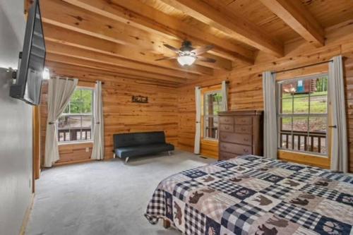 a log cabin bedroom with a bed and a couch at Main Lodge at Lake Forest Cabins in Eureka Springs