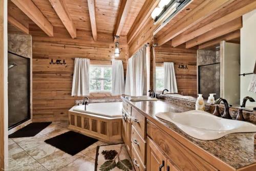a bathroom with two sinks and a tub at Main Lodge at Lake Forest Cabins in Eureka Springs