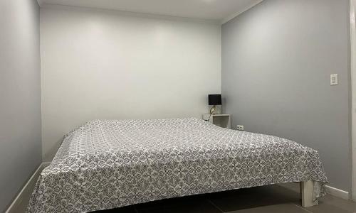 a bedroom with a bed in a white wall at Apartment Curacao in Willemstad