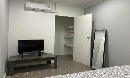 um quarto com uma televisão e uma mesa com uma cama em Apartment Curacao em Willemstad