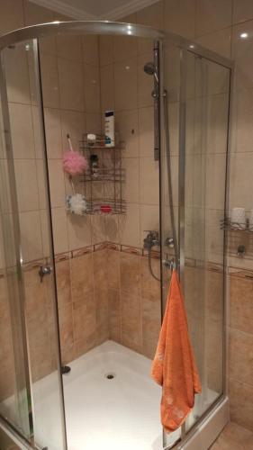 uma cabina de duche com uma toalha laranja na casa de banho em Апартамент на метри от плажа em Sveti Vlas