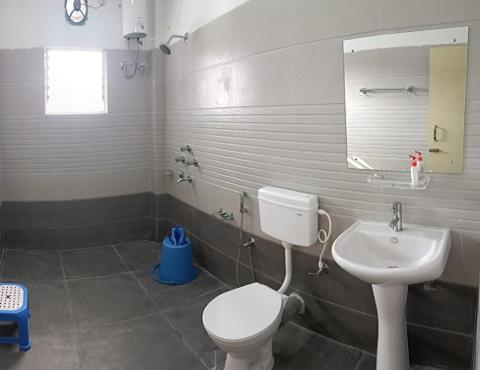 y baño con aseo blanco y lavamanos. en Vanbilas Family Tourism, en Chālsa Mahābāri