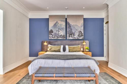 a bedroom with a large bed with blue walls at Wytham Manor House in Cape Town
