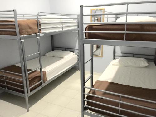 a room with two bunk beds and a bed at The Second Room in Ranau