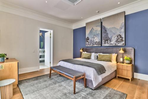 a bedroom with a large bed with blue walls at Manor Boutique House in Cape Town