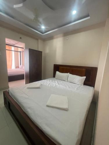 a bedroom with a large bed with white sheets at Reef Terrace Unit in Hyderabad