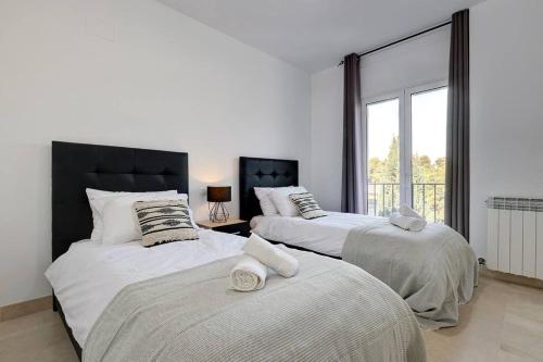 1 dormitorio con 2 camas y ventana en Stunning Duplex 5 minutes from Puerto Banús, en Marbella
