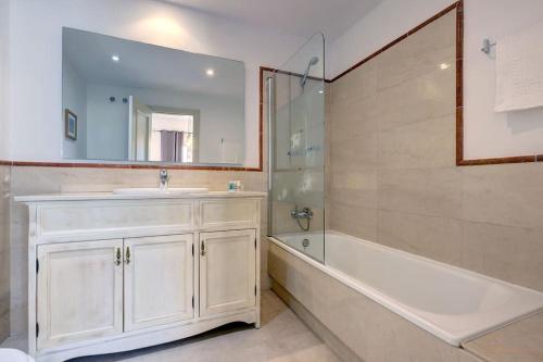 y baño con bañera, lavamanos y ducha. en Stunning Duplex 5 minutes from Puerto Banús, en Marbella