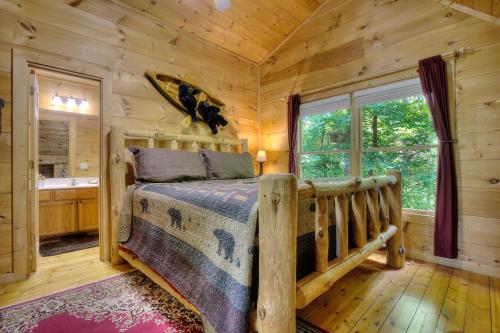 a log cabin bedroom with a bed and a window at A Secluded Bearadise #247 in Sevierville