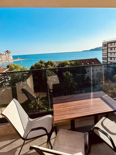 balcón con mesa, sillas y vistas al océano en Carobno jutro, en Rafailovici