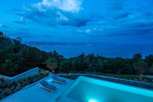 Villa con piscina por la noche en Villa Aura Caesar - 5 Bedroom villa - Ultra modern and luxurious - Stunning sea and town views, en Medveja