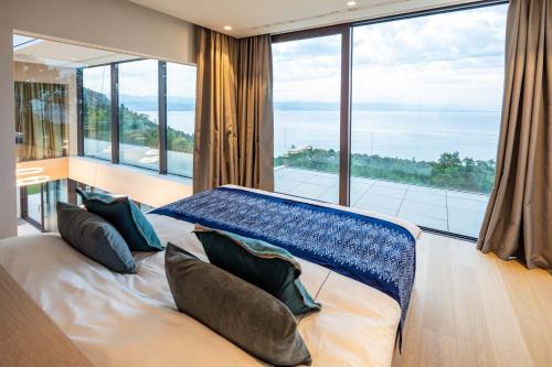1 dormitorio con 1 cama y ventana grande en Villa Aura Caesar - 5 Bedroom villa - Ultra modern and luxurious - Stunning sea and town views, en Medveja
