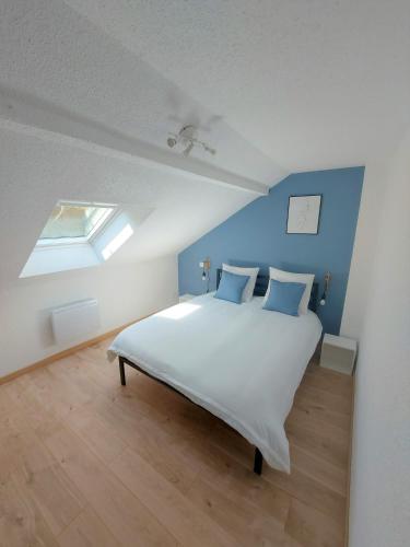 a bedroom with a large white bed with blue walls at ° Appart' Audincourt 2 centre ° in Audincourt