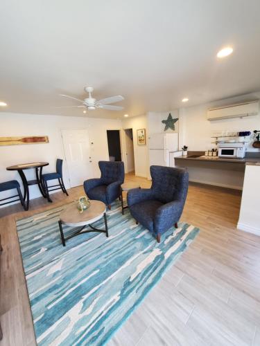 a living room with chairs and a table and a kitchen at Sea Horse Resort in San Clemente