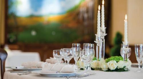 a table with wine glasses and plates and candles at Albergo Ristorante Uliveto in Veroli