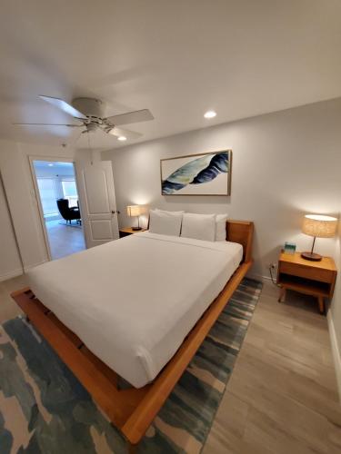 a large white bed in a room with a lamp at Sea Horse Resort in San Clemente