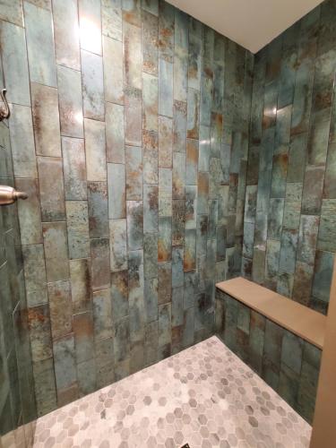 a bathroom with a stone wall with a bench in it at Sea Horse Resort in San Clemente