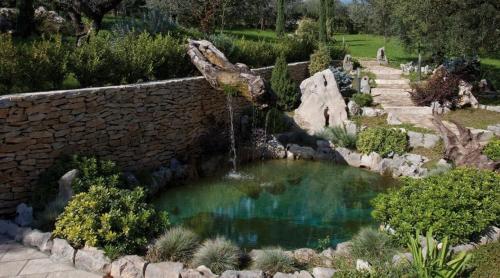 a pool of water in a stone wall with a fountain at Albergo Ristorante Uliveto in Veroli