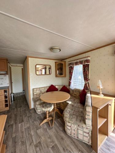 a living room with a couch and a table at Static Caravan in Pwllheli