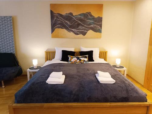 a bedroom with a large bed with two towels on it at Elegant Old Town Toffee Bliss Apartment, SELF Check-In, Steps from Bus Station in Riga
