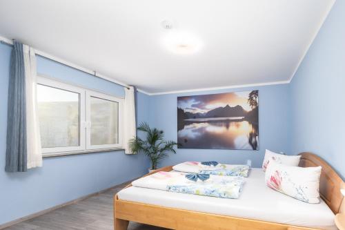 a bedroom with blue walls and a bed and a window at Familienfreundliche 3-Zimmer-Ferienwohnung in Saal an der Donau