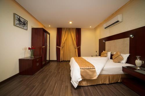Un pat sau paturi într-o cameră la Raoum Inn Buraydah