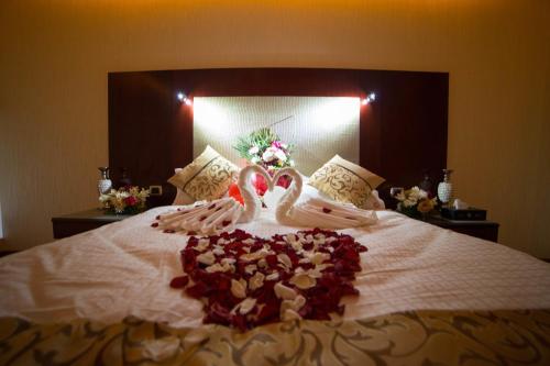 a bed with two swans made out of hearts at رؤوم إن للشقق الفندقية-Raoum Inn Hotel Apartments-Buraydah in Buraydah