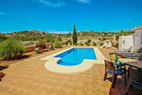 un patio con piscina, mesa y sillas en Quicano - magnificent views and private pool in Lliber, en Lliber