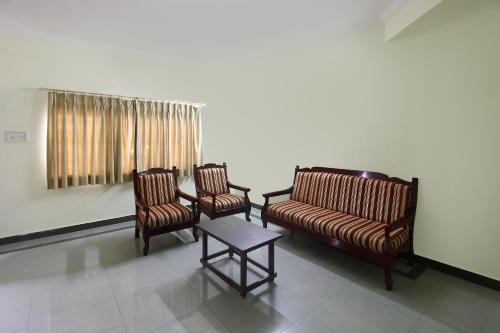 uma sala de espera com duas cadeiras e uma mesa em Alpine Glow Sunrise Near Hyderabad Public School em Ameerpet