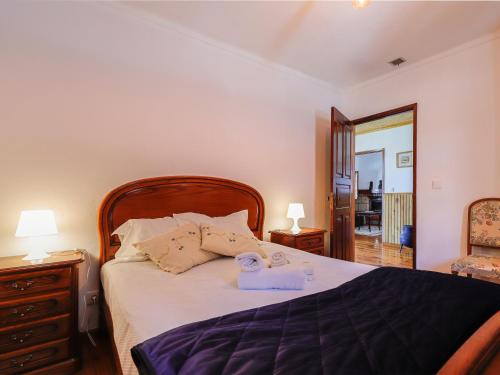 een slaapkamer met een bed met een houten hoofdeinde en een spiegel bij Quinta Soutelinho in Sabrosa