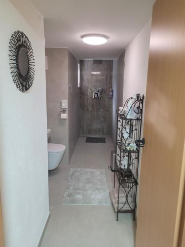 La salle de bains est pourvue d'une douche à l'italienne et de toilettes. dans l'établissement i24rooms - Gästezimmer, FeWo mit eigenem Garten, à Legau