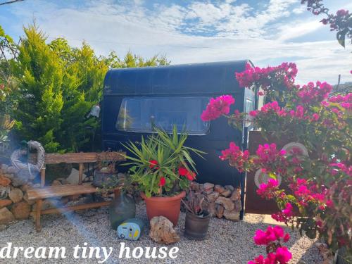 a blue tiny house parked next to a bunch of flowers at Dream Tiny House or Luxus Tent with pool in Chania