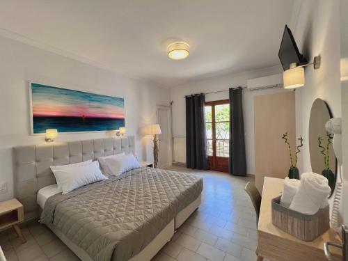 a bedroom with a bed and a painting on the wall at ATHANASIA APARTMENTS in Skiathos Town