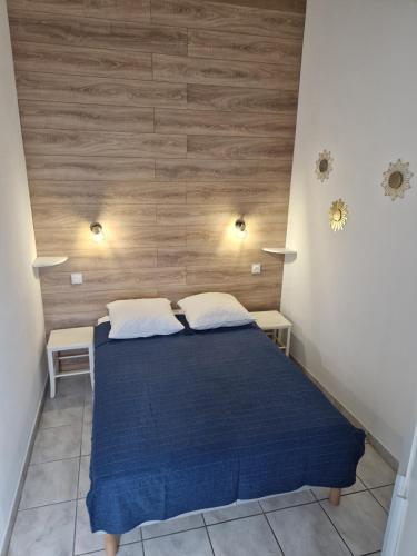 - une chambre avec un lit bleu et 2 oreillers blancs dans l'établissement Charmante maison avec piscine, à Saint-Cyprien