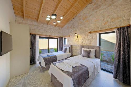 a bedroom with two beds and a flat screen tv at Ader Villa 1 in Fethiye