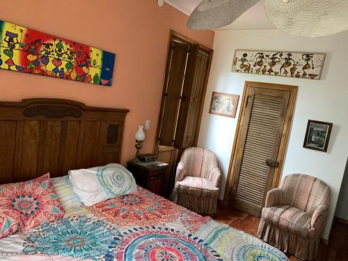 1 dormitorio con 1 cama y 2 sillas en Casa Funes en Funes
