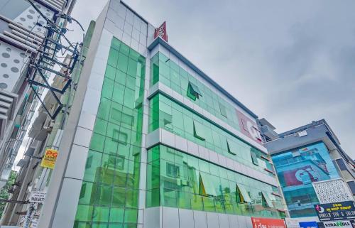 a building with glass windows in a city at Hotel O Sri Sai Guru Comforts in Bengaluru