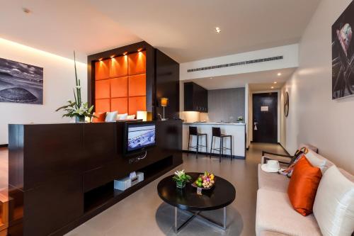 a living room with a couch and a table at Cape Sienna Phuket Gourmet Hotel & Villas - SHA Extra Plus in Kamala Beach