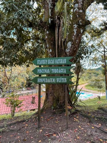 a directional sign in front of a tree at EcoFlat Moderno e Aconchegante in Bonito