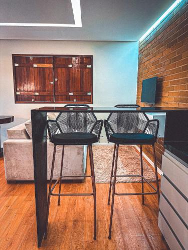 a kitchen with two chairs and a table with a laptop at EcoFlat Moderno e Aconchegante in Bonito