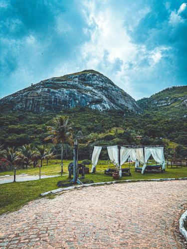 a mountain in the distance with a tent in the grass at EcoFlat Moderno e Aconchegante in Bonito
