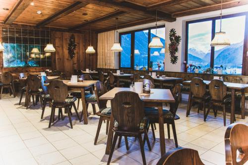 a restaurant with tables and chairs and mountains in the background at Hotel Marko in Oetz