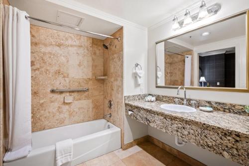 a bathroom with a tub and a sink and a mirror at Apple Farm Inn in San Luis Obispo