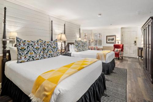 a hotel room with two beds and a chair at Apple Farm Inn in San Luis Obispo